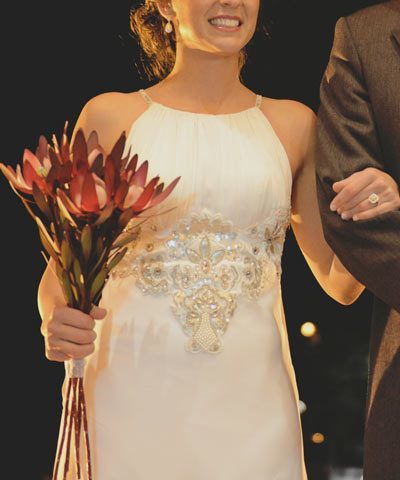 Vestido de novia con escote halter y bordados en tonos mate, hueso y perla