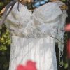 Detalle de un vestido de novia usado con pedrería, encaje y mangas de mostacilla