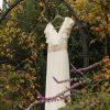 Vestido de novia en la naturaleza hecho en gasa con aplicaciones doradas en la cintura