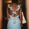 Detalle de espalda de vestido de novia con vuelos en los tirantes y trenzas de hilo de plata