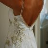 Detalle de espalda abierta de vestido de novia usado con aplicaciones doradas